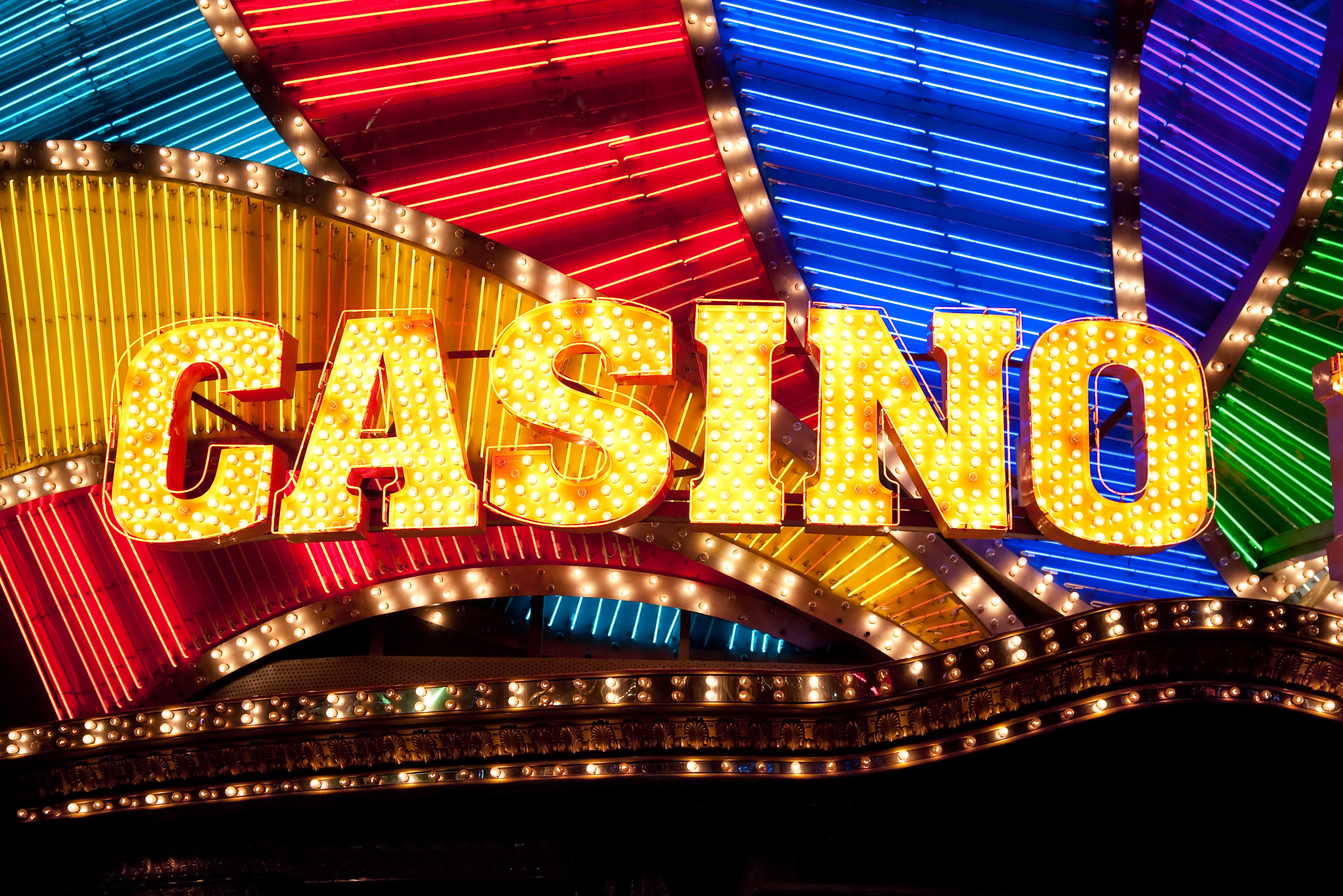 A dynamic graphic showing a variety of casino games like slots, roulette, and blackjack cards.
